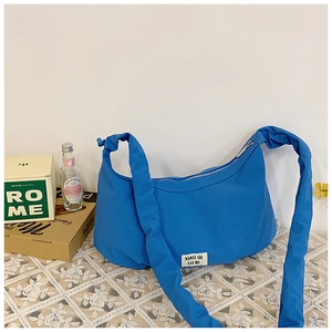 Detailansicht der kleinblauen Nylon-Halbmondtasche mit breitem Faltenriemen und Logo