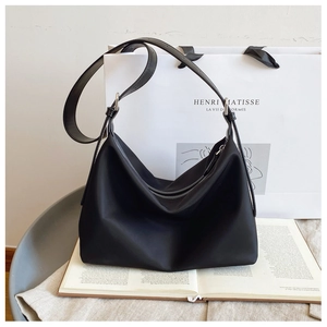Close-up of black nylon hobo tote with adjustable leather strap and silver metal hardware