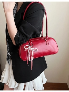 Borsa a cilindro rossa lucida con fiocco di perle e nastro a quadretti su modella