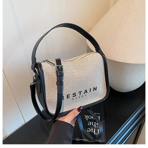 Detail of the vintage canvas crossbody bag with black leather trim and metal hardware