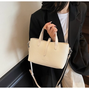 Detailed macro view of the cream white lychee-pattern faux leather handbag texture