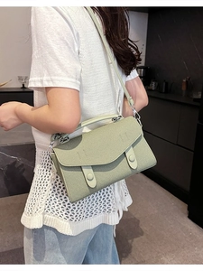 Light green woven textured crossbody bag with silver hardware and adjustable strap