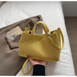 Close-up of bright yellow litchi grain leather tote bag on stylish lifestyle background