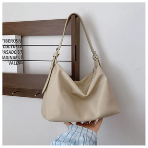 Detail of beige large capacity Hobo bag with adjustable strap and metal hardware