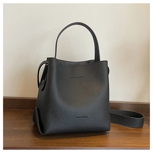Close-up of black lychee grain leather bucket bag showing texture and adjustable strap