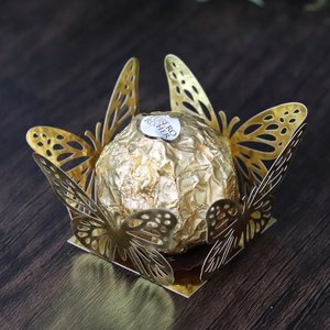 Detail of laser-cut hollow butterfly chocolate wrap in reflective gold mirror finish