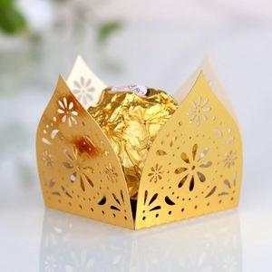 Close-up of golden laser-cut hollow floral candy box for elegant wedding favor favors