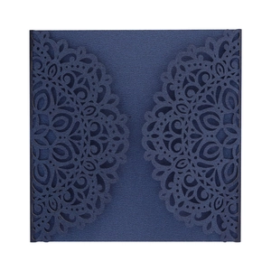 Macro view of laser-cut floral patterns on navy blue square wedding invitation cover