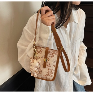 Detail of crossbody bag featuring vintage Teddy Bear pattern and contrast leather trim