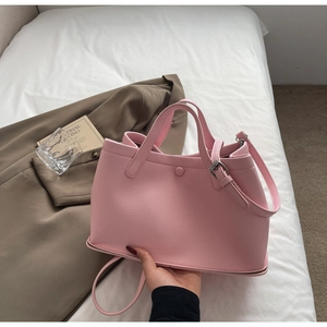 Detailed texture of pink litchi grain leather on a stylish bucket handbag for women