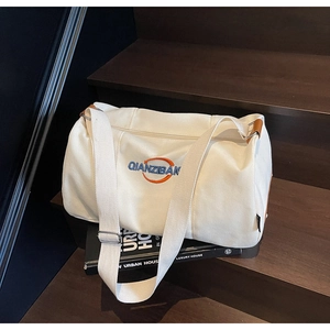 Détail du sac cabas en toile blanche avec broderie bleue et bandoulière réglable
