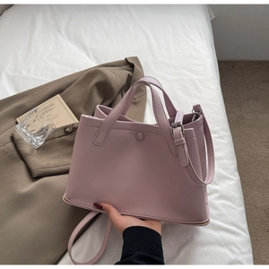 Detail of light pink bucket bag with lychee texture and adjustable shoulder strap