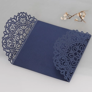 Close-up of navy blue laser-cut wedding invitation with intricate floral mandala patterns