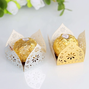 Close-up of laser-cut hollow lace candy wrappers in gold and silver pearlescent paper