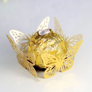 Macro detail of laser-cut butterfly hollow candy box made from gold pearlescent paper