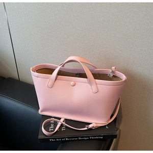 Pink lychee texture bucket bag with magnetic closure on decorative books