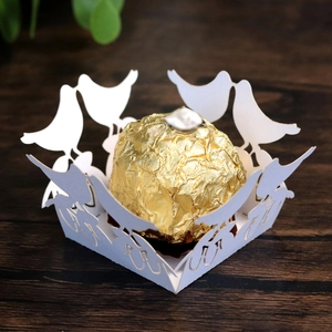 Laser-cut white wedding favor box with bird motif featuring a gold foil chocolate ball
