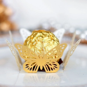 Laser-cut hollow butterfly chocolate holders in gold and white for party decor