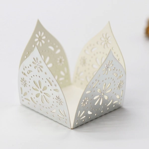 Detail of laser-cut floral pattern on a silver hollow paper candy box or cupcake wrapper