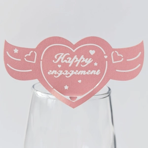 Carte de verre rose en forme de cœur ailé avec texte Happy Engagement sur verre
