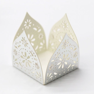 Detail showing white laser-cut hollow flower patterns on wedding cupcake favor boxes