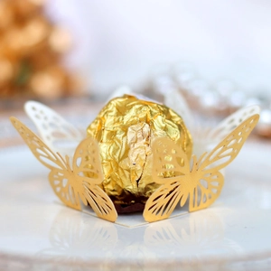 Macro shot of elegant laser-cut golden butterfly chocolate wrapper for wedding party decor