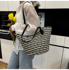 Dettaglio della borsa tote intrecciata con motivi geometrici bianchi e neri