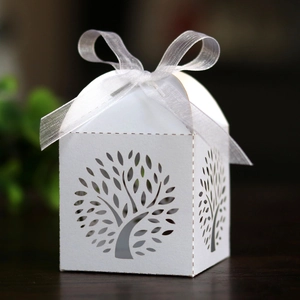 Detail of white laser-cut Tree of Life candy box with elegant silver organza ribbon bow