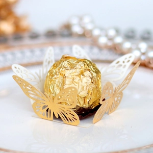 Macro shot of gold laser-cut butterfly chocolate holder for party table decor