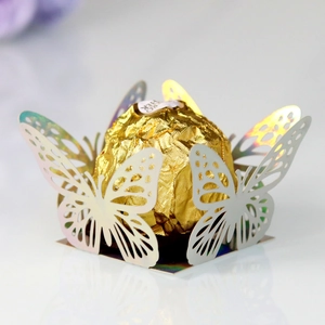 Detail of laser-cut iridescent butterfly candy box with hollow patterns for wedding decor