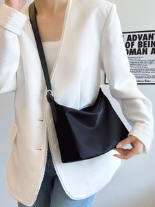 Minimalist black tote bag in matte nylon with adjustable strap for commuting