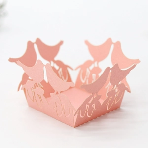Close-up of laser cut pink candy box with intricate bird pattern and pearlescent finish