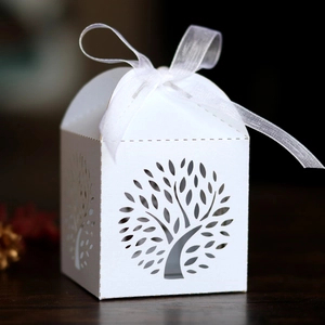 Detail of white tree of life laser cut wedding favor box with elegant white ribbon bow