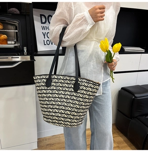 Dettaglio della borsa tote intrecciata bianca e nera con manici in pelle a spalla