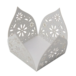 Close-up of laser-cut white cardstock candy box with elegant daisy floral patterns
