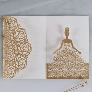 Detail of laser-cut wedding invitation featuring golden glitter rose and bridal silhouette