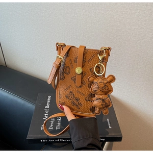 Detail of brown litchi pattern PU leather phone bag with cute bear print and gold buckle