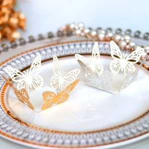 Detail of laser-cut hollow butterfly candy box in white and gold for festive parties