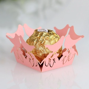 Detail view of pink laser-cut paper chocolate wrapper with elegant bird motif decoration