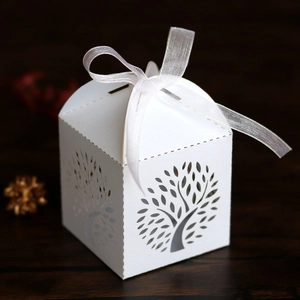 Detailed laser-cut Tree of Life wedding favor box with a white organza ribbon bow