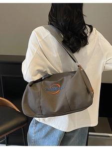 Sac fourre-tout minimaliste en toile porté par un mannequin en couleur vert gris foncé