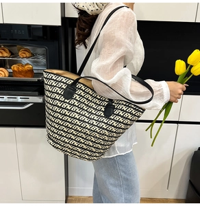 Vista dettagliata della borsa tote intrecciata con motivo geometrico e manici in pelle