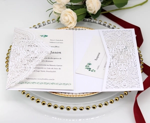 Elegant laser cut lace wedding invitation with floral details and ivory RSVP cards