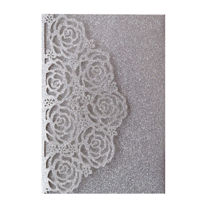 Detailed laser-cut silver glitter invitation featuring intricate rose flower lace designs