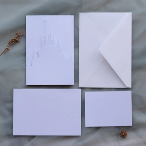 Detail of laser-cut white castle invitation set with envelope and blank cards for weddings
