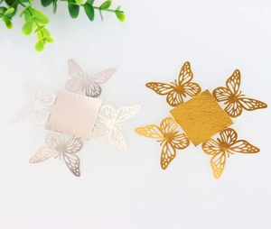 Close-up of laser-cut gold and silver butterfly hollow candy box cards for parties