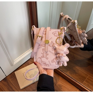 Detail of pink crossbody phone bag with teddy bear prints and matching bear charm