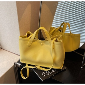 Detail of yellow lychee grain leather tote bag with top handles and adjustable strap