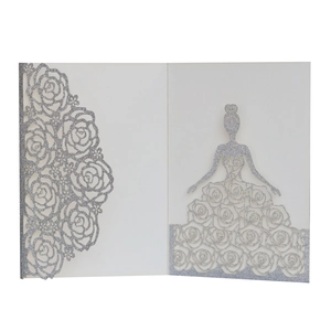 Close-up of laser-cut rose and woman silhouette on white silver glitter invitation