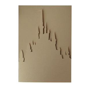 Detailed laser-cut 3D golden castle silhouette on wedding invitation card